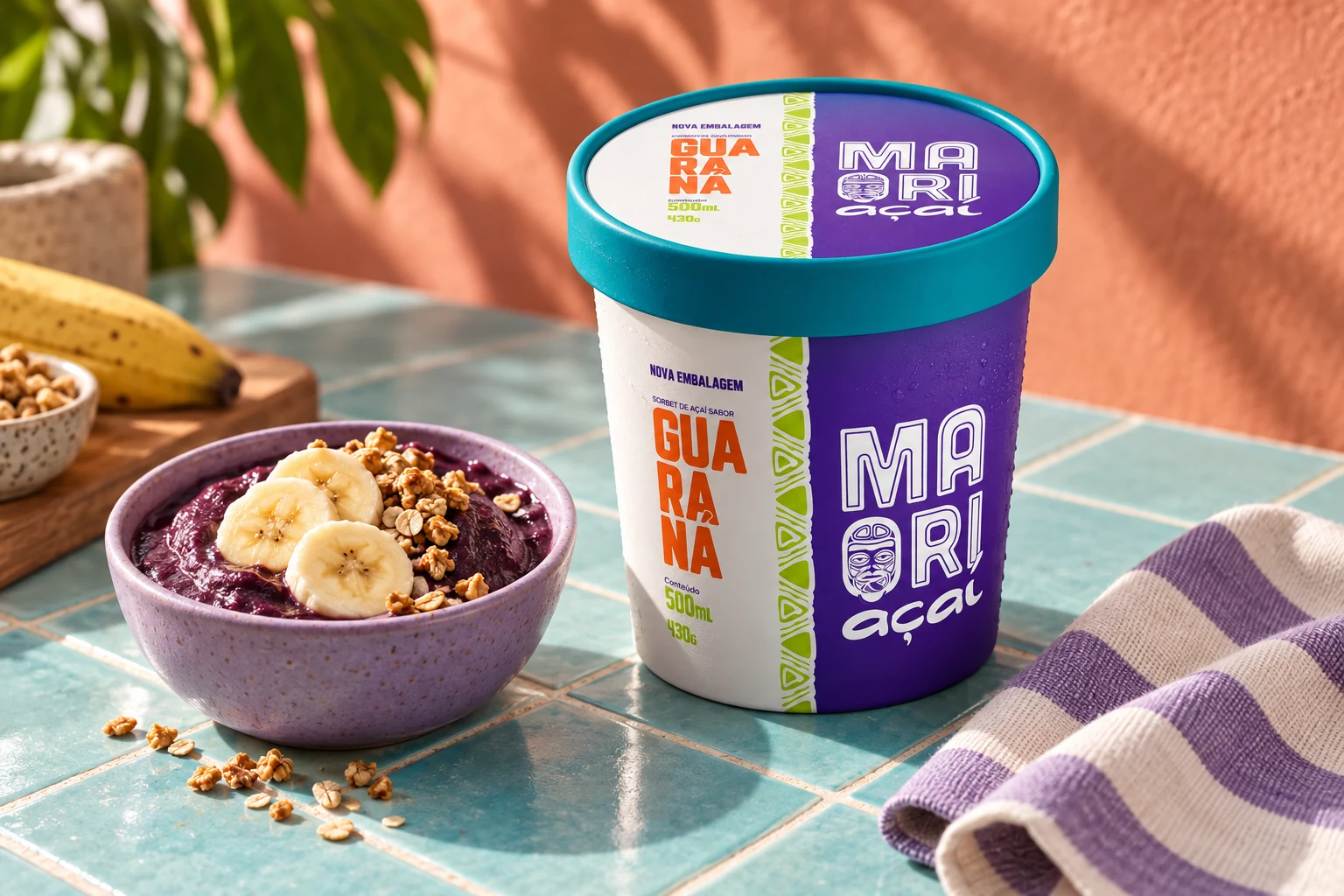 Pote Maori Açaí com tampa turquesa ao lado de açaí servido com banana e granola